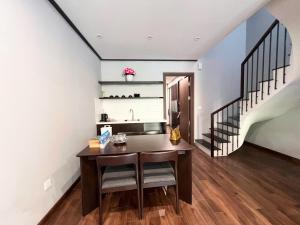 a kitchen with a wooden table and a staircase at Lotus Wyndham Thanh Thủy in Phú Thọ