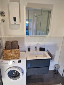 Un baño con lavadora y lavabo. en Gästehaus in Köln Rath-Heumar, en Colonia