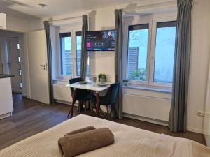 Habitación con cama, mesa y ventana en Gästehaus in Köln Rath-Heumar, en Colonia