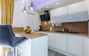 una cocina con armarios blancos y un bol de fruta en una barra en 3 Bedroom Awesome Apartment In Kavran, en Kavran