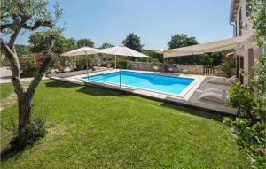 a swimming pool with an umbrella and a yard at Holiday Home Tinjan 56 in Tinjan +41 photos