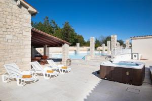 patio z krzesłami i wanną z hydromasażem przy basenie w obiekcie Villa Lux Casa Histria 2 w mieście Pazin