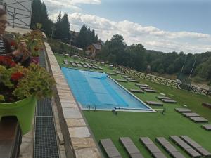 a large swimming pool with chairs and flowers on a balcony at Studio SimpaKop in Kopaonik +30 photos