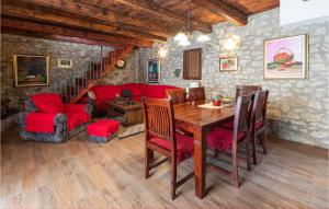 a dining room with a table and red chairs at Amazing Home In Ploce With Sauna in Ploče