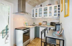 Una cocina con gabinetes blancos y una mesa con sillas. en Beautiful Home In Carpentras, en Carpentras 16 fotos más