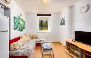 un soggiorno con un divano rosso e una TV di 3 Bedroom Awesome Home In Krk a Risika