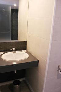 a bathroom with a sink and a mirror at Checkin Urban Nevada in Granada +37 photos