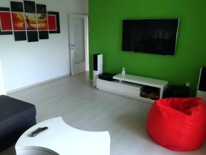 Sala de estar verde con silla roja y TV en Apartment Alan en Rijeka