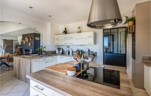 eine Küche mit weißen Schränken und einer Holzarbeitsplatte in der Unterkunft Nice Home In La Londe Les Maures in La Londe-les-Maures