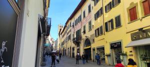 a group of people walking down a street with buildings at Urban Center Arezzo in Arezzo