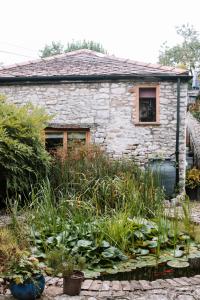 a stone house with a garden in front of it at Longbridge Cottage in Shepton Mallet