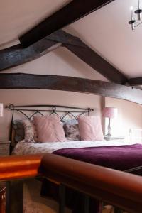 a bedroom with a large bed with wooden beams at Longbridge Cottage in Shepton Mallet