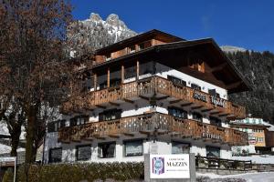 un grande edificio con balcone in legno di Hotel Vajolet a Mazzin