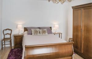 a bedroom with a bed and a wooden cabinet at 2 Bedroom Nice Home In Plonevez Porzay in Plonévez-Porzay