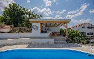 a pergola over a swimming pool next to a house at Villa Ancora in Jadranovo