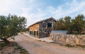 a stone building on a dirt road next to a stone wall at Holiday Home Jezera With A Fireplace 04 in Jezera