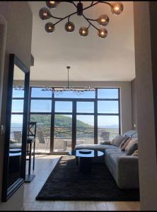 a living room with a couch and a large window at Apartment Mountain View Haven in Kopaonik