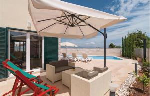 un patio con ombrellone e sedie bianchi e una piscina di Holiday Home Postira With Sea View Ix a Postira (Postire)