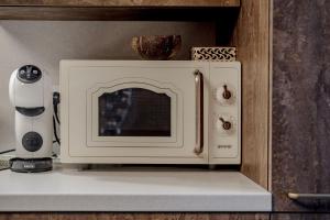 a microwave oven sitting on a shelf in a kitchen at Gamtos pinklės in Žiūrai