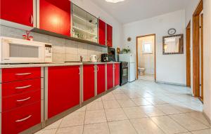 a kitchen with red cabinets and a microwave at Two-Bedroom Apartment In Vir in Vir