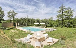a backyard with a pool and chairs and a table and a pool at Villa Oleandro in Fauglia