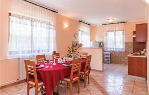 a kitchen and dining room with a table and chairs at Holiday Home Krse V in Premantura