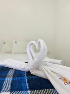 a towel in the shape of a heart on a bed at Mar Suites Toninhas in Ubatuba +14 photos