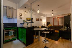 une cuisine avec des placards verts et un salon dans l'établissement Petar Apartment-City Center, Ohrid, à Ohrid