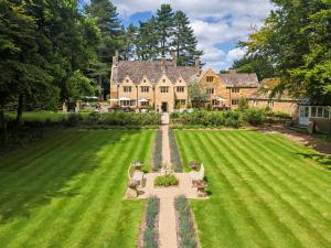 an aerial view of a large house with a green lawn at Charingworth Manor in Chipping Campden