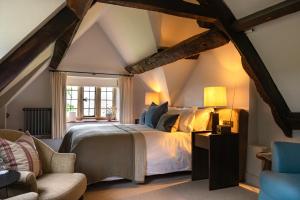 a bedroom with a large bed in the attic at Charingworth Manor in Chipping Campden
