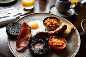 a plate of breakfast food with eggs bacon and beans at Charingworth Manor in Chipping Campden