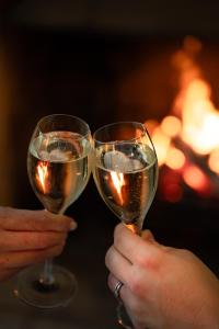 two people holding up glasses of white wine at Charingworth Manor in Chipping Campden
