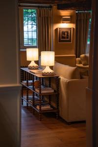 two lamps on tables in a living room with a couch at Charingworth Manor in Chipping Campden