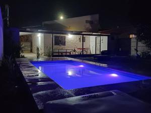 a swimming pool with blue lights in a yard at night at Casita Ukuchay Pcia Bs As in General Belgrano