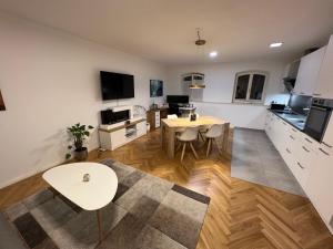 a living room with a table and a kitchen at Deluxe Apartments mit Arbeitsplatz im Denkmalhaus, beste und ruhige zentrale Lage von Halle Saale WE1 in Halle an der Saale
