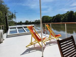 two chairs sitting on the deck of a boat at Péniche sur la Seine in Conflans-Sainte-Honorine