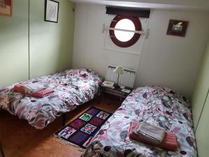 a bedroom with two beds and a window at Péniche sur la Seine in Conflans-Sainte-Honorine +4 photos