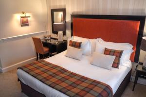 a hotel room with a bed and a desk at Charingworth Manor in Chipping Campden