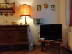 a living room with a television and a table with a lamp at Casa Ena in Roccaraso