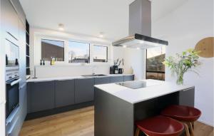 eine Küche mit Spüle und Theke mit Hockern in der Unterkunft Stunning Home In Lembruchdümmer See in Lembruch