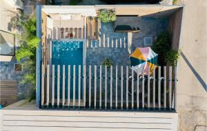 a fence with an umbrella in front of a house at Beautiful Home In Privlaka in Privlaka