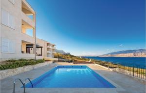 dom z basenem obok wody w obiekcie 2 Bedroom Beautiful Apartment In Pag w mieście Pag