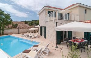 una piscina con sedie, tavolo e ombrellone di Holiday Home Postira With Sea View Ix a Postira (Postire)