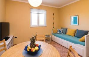 a living room with a couch and a table with a bowl of fruit at Holiday Home Podgradina 01 in Gradina