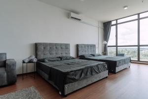 a bedroom with two beds and a large window at SUMMER SUITES APARTMENT CASETTA HOMESTAY 3 at Kota Samarahan Kuching in Kampong Samawang
