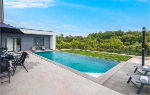 a swimming pool with a table and chairs on a patio at Awesome Home In Zminj With Wifi in Žminj +24 photos