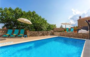 ein Swimmingpool mit zwei Stühlen und einem Sonnenschirm in der Unterkunft Villa Ala in Garica