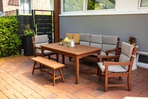 a wooden table and chairs on a patio at Visiet - Ferienwohnungen in Emden in Emden