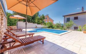 ein Pool mit zwei Bänken und einem Sonnenschirm in der Unterkunft Amazing Home In Crikvenica With Wifi in Dramalj