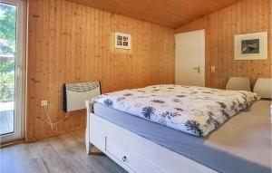 ein Schlafzimmer mit einem Bett in einem Zimmer mit Holzwänden in der Unterkunft Amazing Home In Mirow Ot Granzow in Granzow
